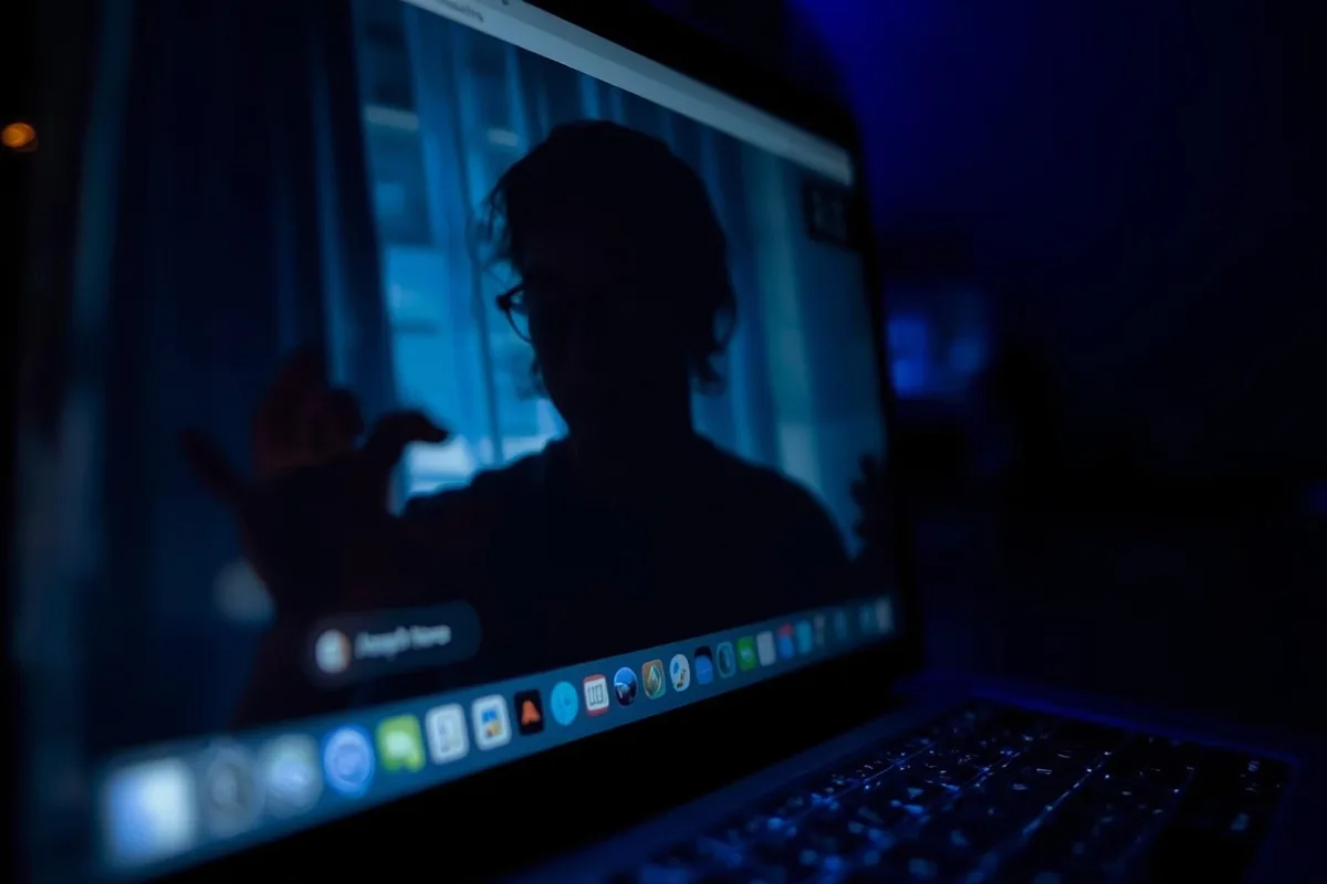 Laptop screen displaying blurred video chat interface, reflecting anonymity and digital voyeurism.